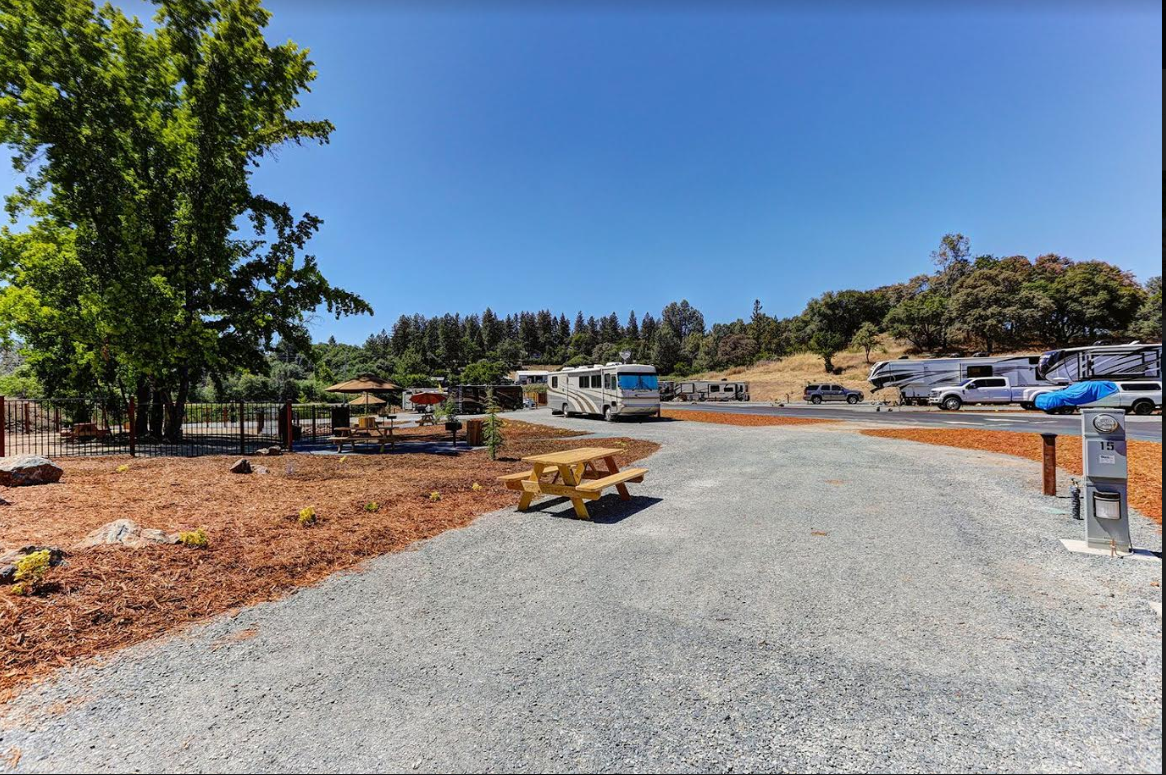 Spacious pull-through RV site at Auburn RV Resort with a gravel pad and picnic area